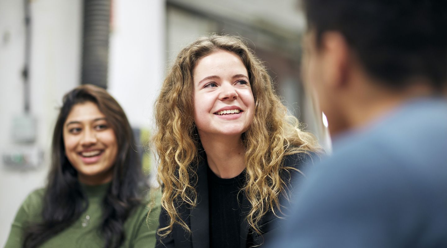 Students laughing and chatting to other students