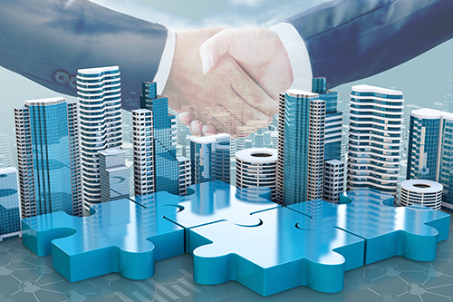 Buildings connected by jigsaw pieces with two hands shaking imposed above