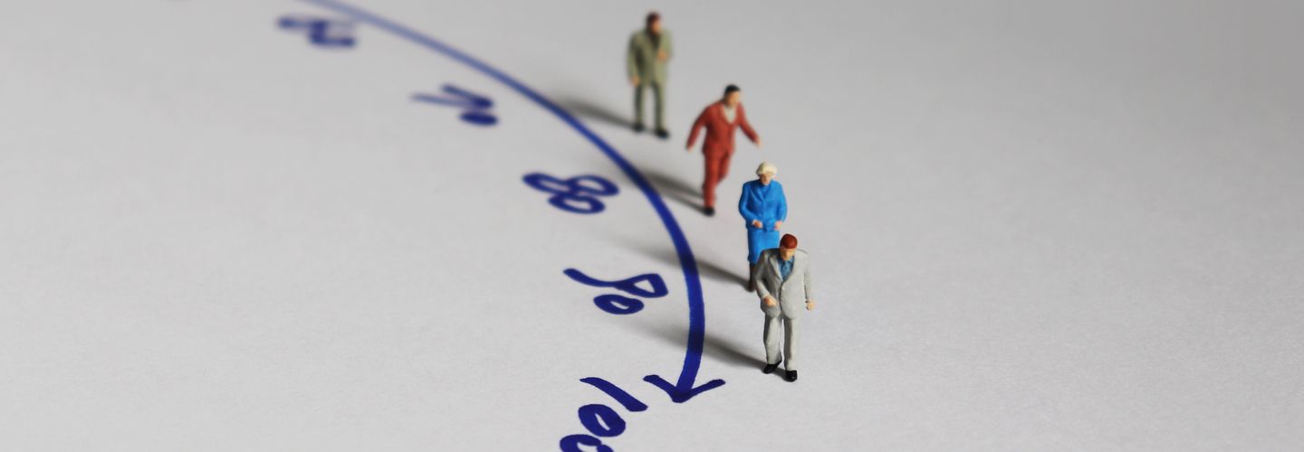 Mini figures posed along a curve line with numbers leading up to 100.