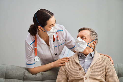 Female nurse laughing with elderly man in a care home
