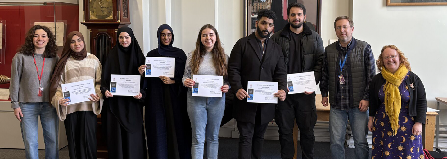 A group of people pose with certificates