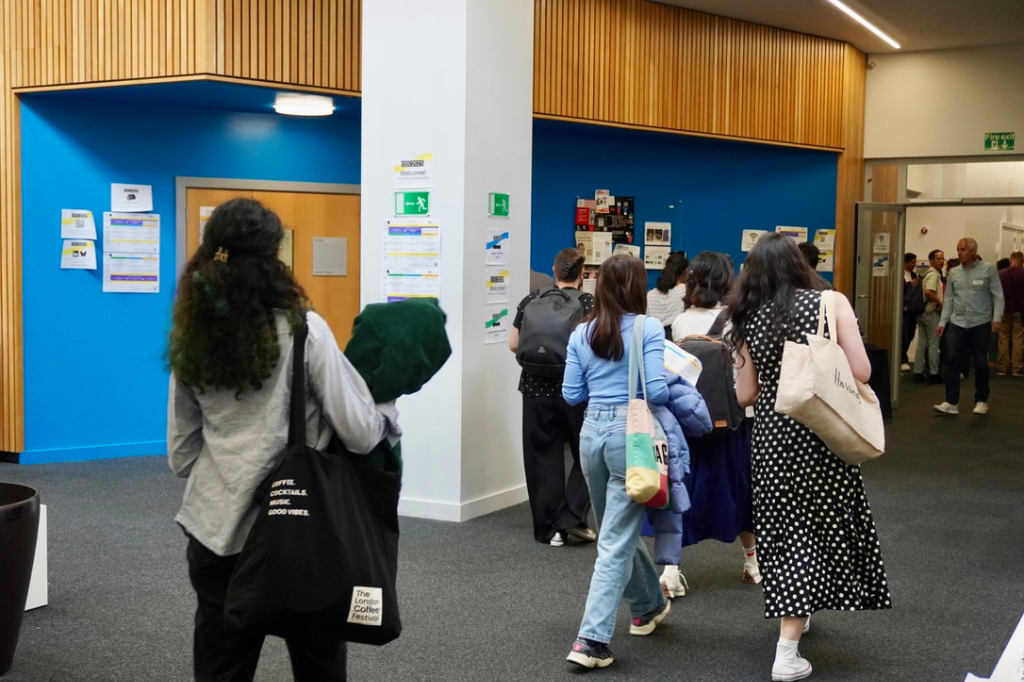HCID guests and members walk around the room, grabbing coffee and tea. 