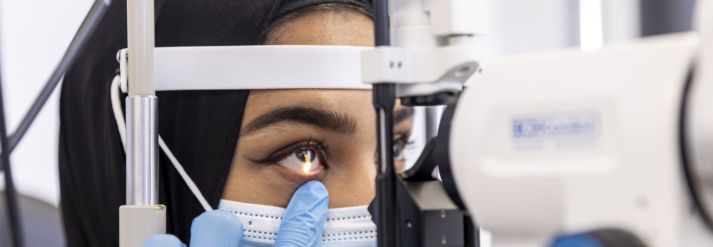 An optometrist checks a patient’s eyes using a machine