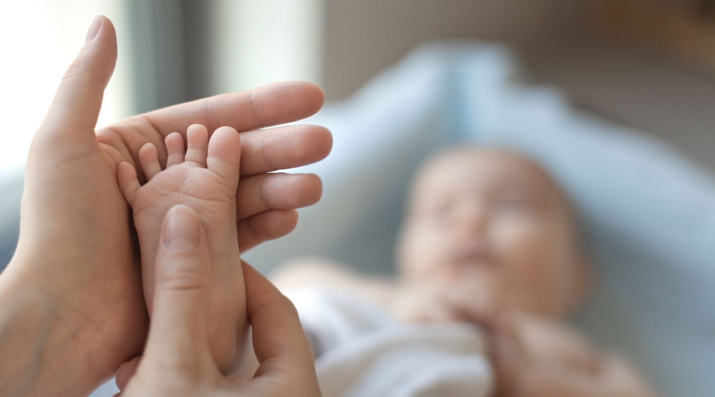 doctor examining a baby, checking the reflexes of the newborn