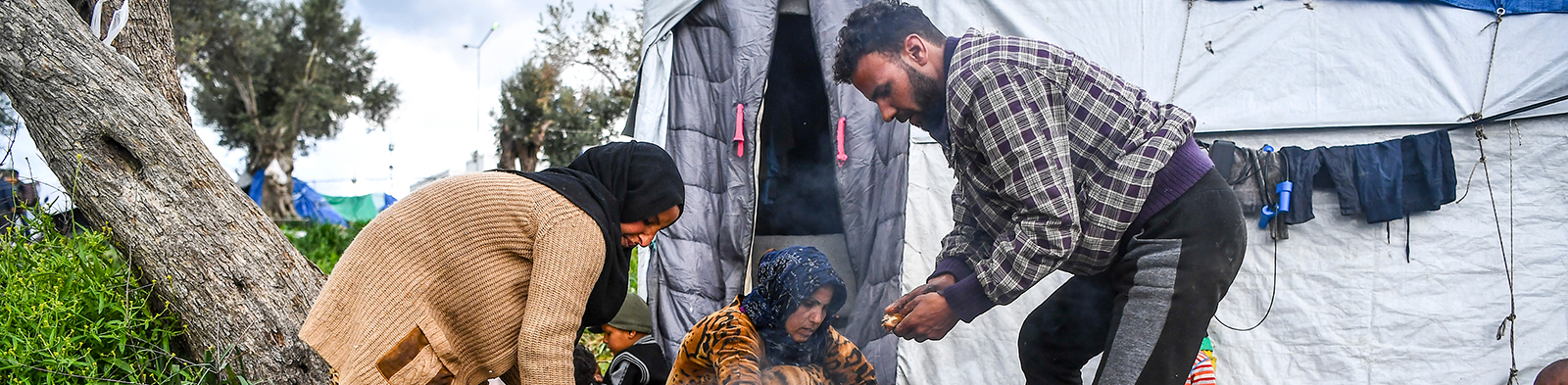Man and woman light a fire in Moria refugee camp