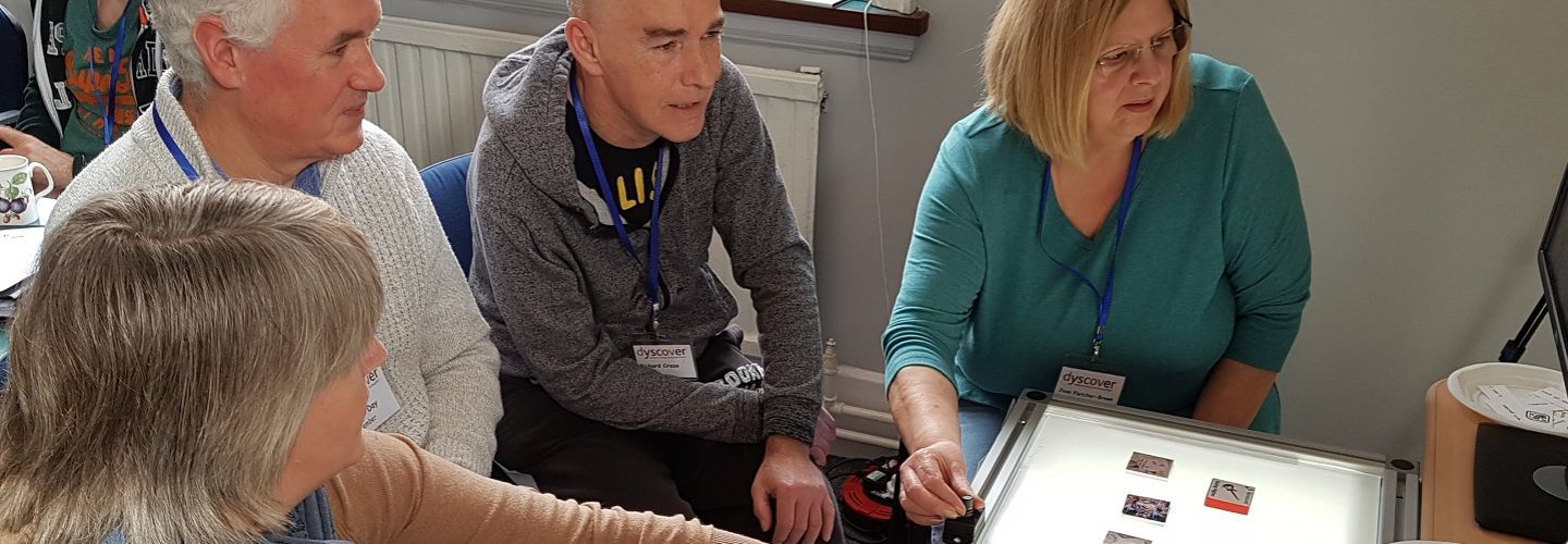 Attendees at INCA event, looking at tiles on a lightbox.