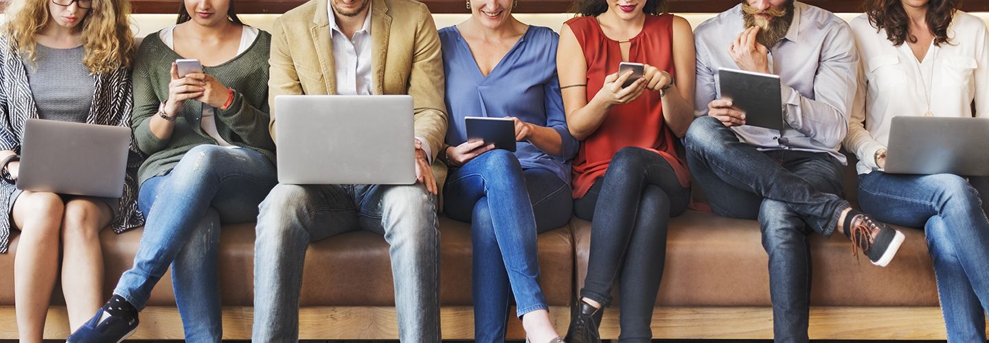Multiple users sitting with their digital devices.