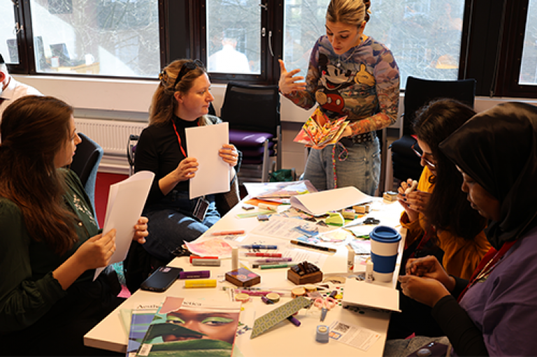 A group of people make zines at a table