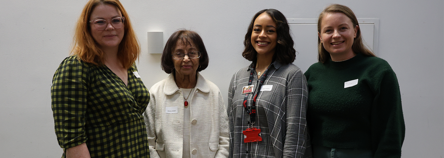 Four women stand and pose