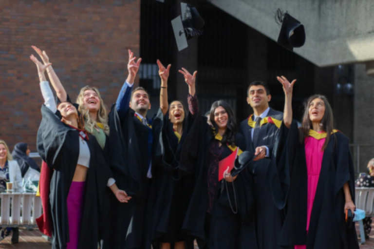 students throwing mortarboards