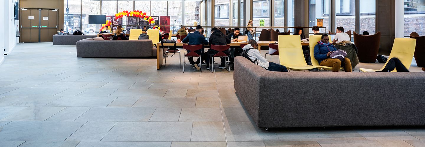 Student sitting in multi-use space by the main entrance.