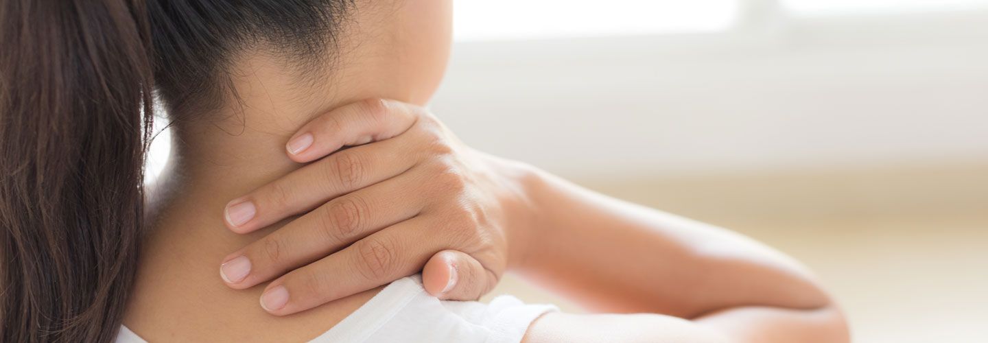 Closeup of woman with neck and shoulder pain.