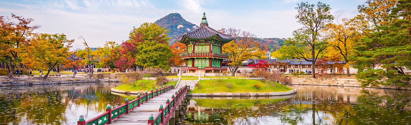 Bridge leading to Gyeongbokgung palace garden surrounded by a pond