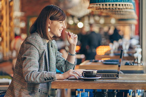 A woman smiles as she works in a bar