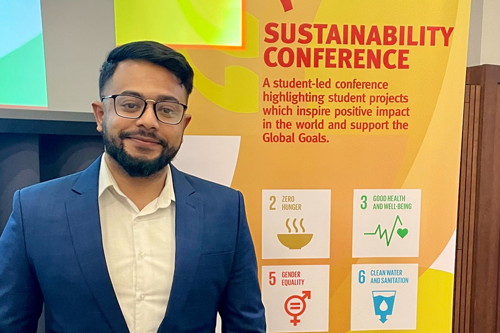Student Phahmee Khalid stands in front of a poster at the LSSC23
