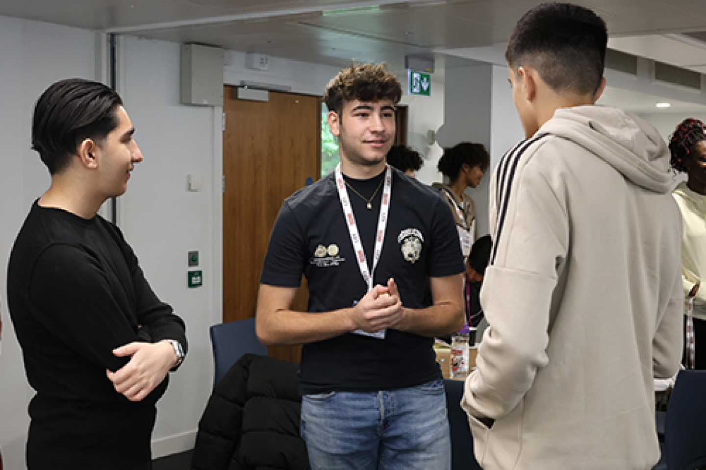 Three young people chat to each other 
