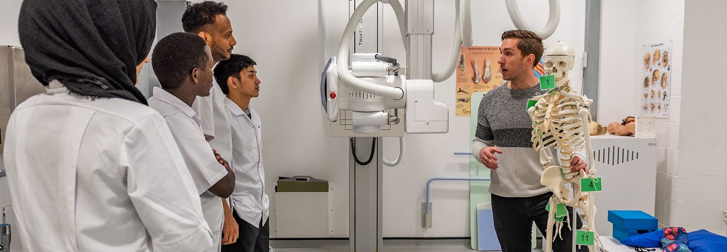 Male academic talking to students in the Radiography room