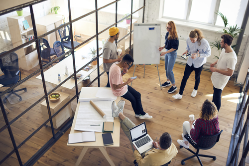 A group of people discusses things in a shared working space